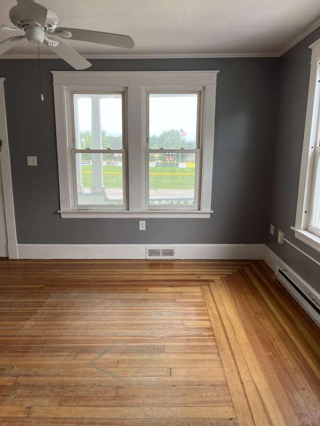 107 May St, Biddeford, ME 04005 - spare room with ceiling fan, crown molding, a baseboard radiator, and wood finished floors
