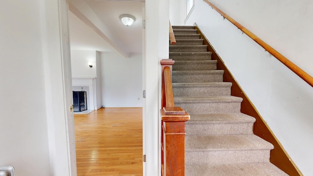 69 Androscoggin Ave, Lewiston, ME 04240 - stairs featuring hardwood / wood-style floors and a fireplace