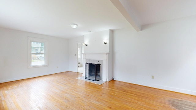 69 Androscoggin Ave, Lewiston, ME 04240 - unfurnished living room featuring light wood-style floors and a fireplace with flush hearth