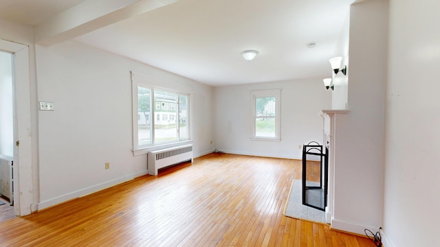 69 Androscoggin Ave, Lewiston, ME 04240 - unfurnished living room featuring radiator, light wood finished floors, and a fireplace