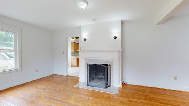 69 Androscoggin Ave, Lewiston, ME 04240 - unfurnished living room with plenty of natural light, light wood finished floors, a fireplace, and ceiling fan
