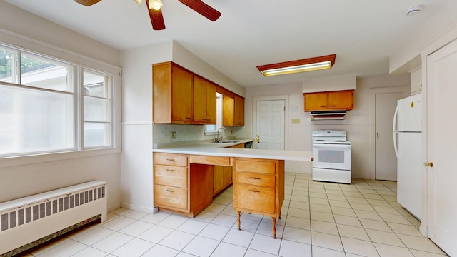 69 Androscoggin Ave, Lewiston, ME 04240 - kitchen with white appliances, radiator, a peninsula, light countertops, and ceiling fan