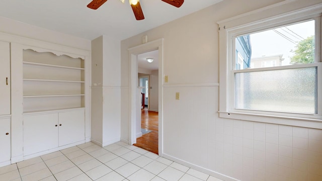 69 Androscoggin Ave, Lewiston, ME 04240 - unfurnished room with ceiling fan, light tile patterned flooring, and a wainscoted wall