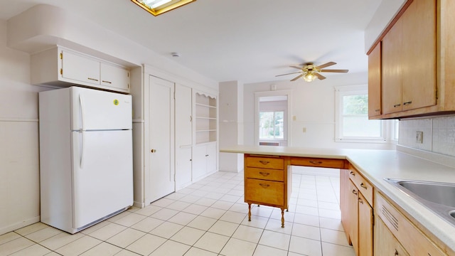 69 Androscoggin Ave, Lewiston, ME 04240 - kitchen with freestanding refrigerator, a ceiling fan, light countertops, backsplash, and light tile patterned floors