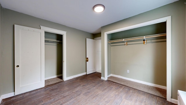 69 Androscoggin Ave, Lewiston, ME 04240 - unfurnished bedroom with wood finished floors and multiple closets