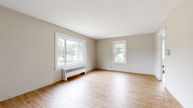 69 Androscoggin Ave, Lewiston, ME 04240 - empty room with radiator heating unit and light wood-style floors