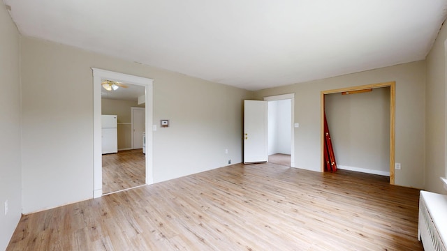 69 Androscoggin Ave, Lewiston, ME 04240 - unfurnished bedroom featuring freestanding refrigerator, wood finished floors, and a closet