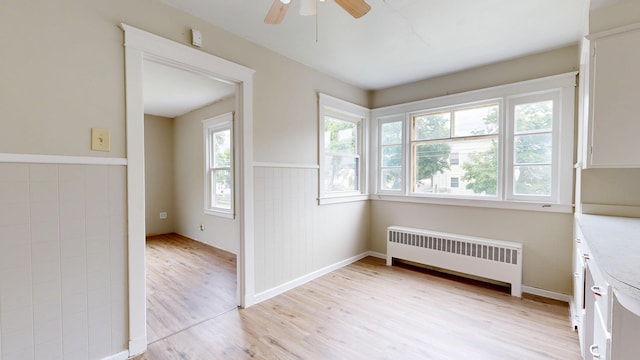 69 Androscoggin Ave, Lewiston, ME 04240 - unfurnished room featuring radiator heating unit, light wood-style floors, and ceiling fan