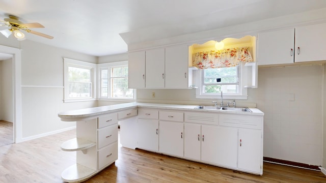 69 Androscoggin Ave, Lewiston, ME 04240 - kitchen with light countertops, light wood-style floors, ceiling fan, and white cabinets