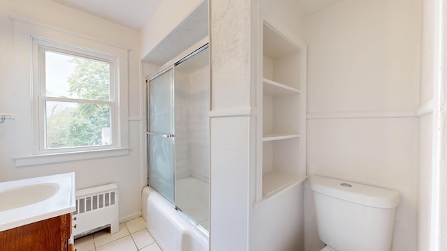 69 Androscoggin Ave, Lewiston, ME 04240 - bathroom with radiator heating unit, vanity, shower / bath combination with glass door, and tile patterned floors