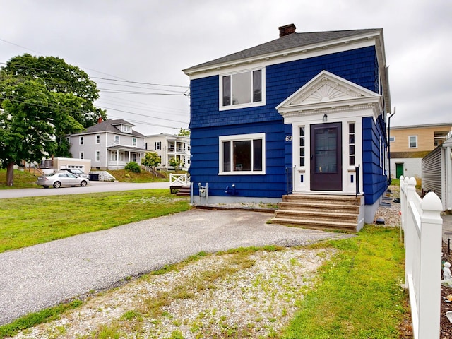 69 Androscoggin Ave, Lewiston, ME 04240 - view of front of home featuring entry steps, a chimney, and a front lawn