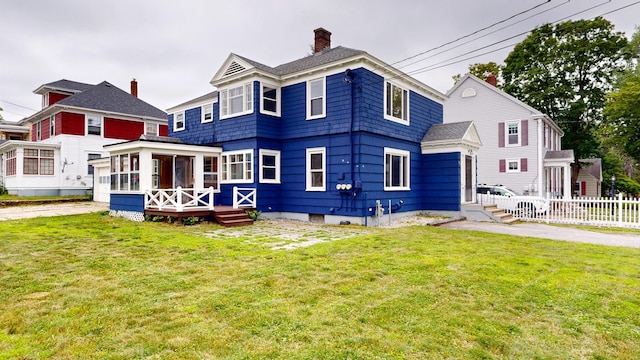 69 Androscoggin Ave, Lewiston, ME 04240 - view of front of property with a sunroom, a chimney, and a wooden deck