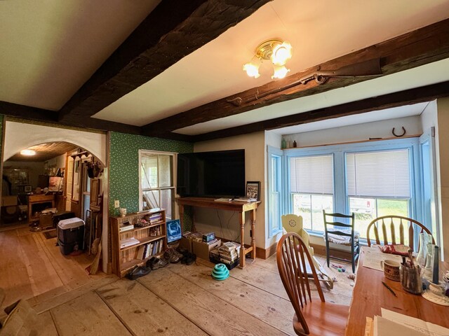 610 E Sangerville Rd, Sangerville, ME 04479 - dining area featuring arched walkways, beam ceiling, and hardwood / wood-style floors