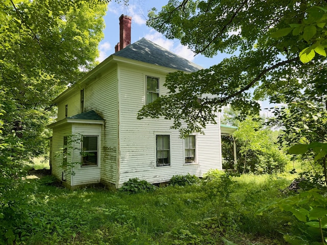 610 E Sangerville Rd, Sangerville, ME 04479 - view of side of property with a chimney and roof with shingles