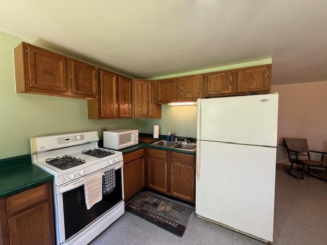 47 Tranquility Ln, Perry, ME 04667 - kitchen featuring white appliances, dark countertops, and brown cabinetry