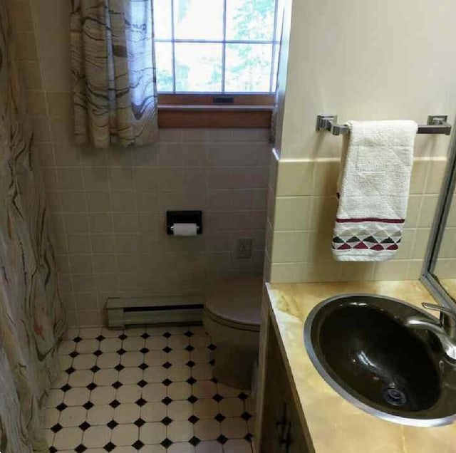 124 Main Rd, Westport Island, ME 04578 - bathroom with tile walls, baseboard heating, vanity, tile patterned floors, and a wainscoted wall