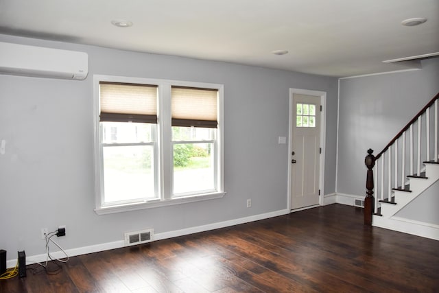 26 Elm St, Old Town, ME 04468 - foyer with wood finished floors, stairs, and an AC wall unit