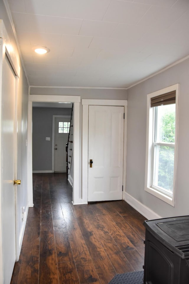26 Elm St, Old Town, ME 04468 - unfurnished bedroom featuring dark wood finished floors, a wood stove, crown molding, and a closet