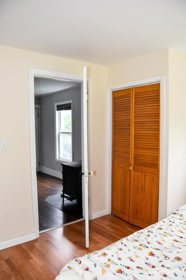 26 Elm St, Old Town, ME 04468 - bedroom with wood finished floors, a closet, and a wood stove