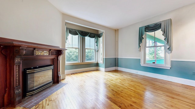 93 Fessenden St, Portland, ME 04103 - unfurnished living room with healthy amount of natural light, wood-type flooring, and a glass covered fireplace