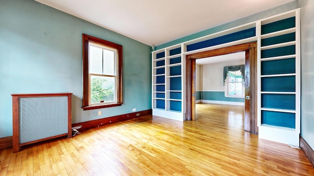 93 Fessenden St, Portland, ME 04103 - spare room featuring hardwood / wood-style floors, built in shelves, and radiator