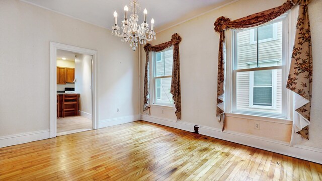 93 Fessenden St, Portland, ME 04103 - empty room with a chandelier, hardwood / wood-style floors, healthy amount of natural light, and crown molding