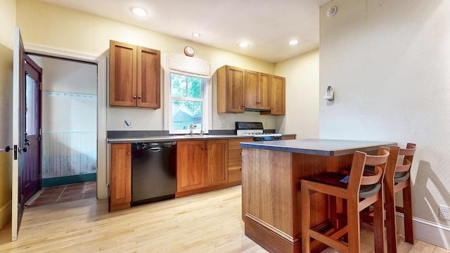 93 Fessenden St, Portland, ME 04103 - kitchen featuring dishwasher, white range with gas stovetop, light wood-type flooring, a kitchen breakfast bar, and brown cabinets