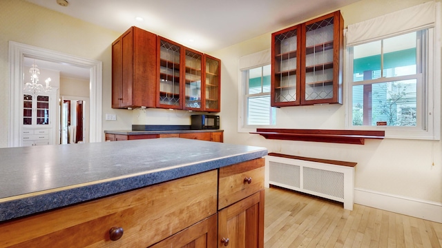93 Fessenden St, Portland, ME 04103 - kitchen featuring radiator, light wood-style floors, dark countertops, and healthy amount of natural light