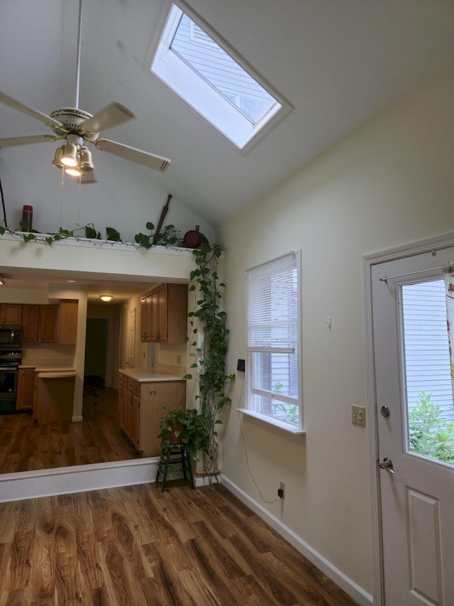 411 Augusta Rd, Belgrade, ME 04917 - unfurnished living room featuring healthy amount of natural light, dark wood-type flooring, a skylight, high vaulted ceiling, and ceiling fan