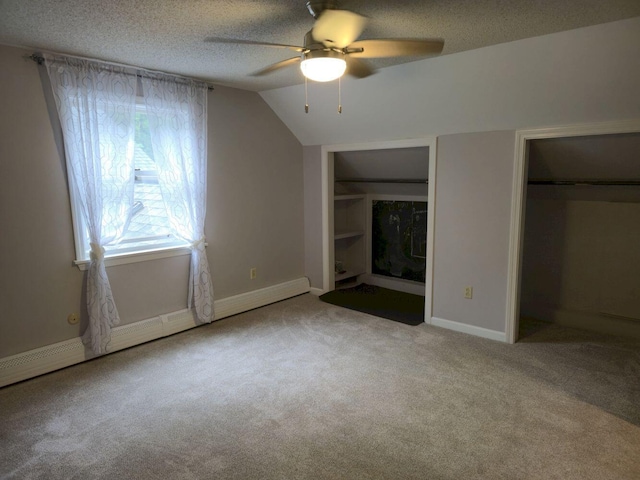 411 Augusta Rd, Belgrade, ME 04917 - unfurnished bedroom with carpet, a textured ceiling, two closets, lofted ceiling, and a ceiling fan