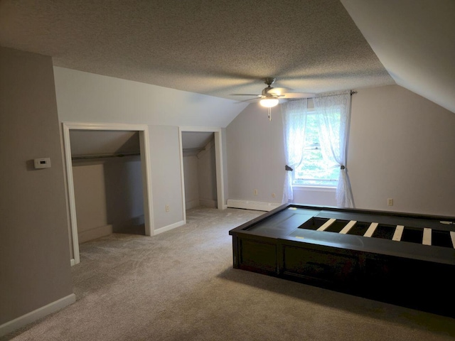 411 Augusta Rd, Belgrade, ME 04917 - additional living space featuring vaulted ceiling, a ceiling fan, light colored carpet, a textured ceiling, and baseboard heating