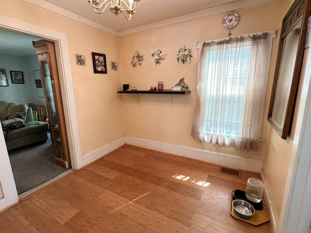31 Blake St, Brewer, ME 04412 - unfurnished dining area with wood finished floors, a chandelier, crown molding, and a textured ceiling