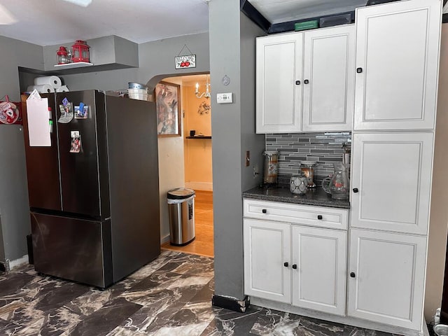 31 Blake St, Brewer, ME 04412 - kitchen with freestanding refrigerator, dark marble finish floors, tasteful backsplash, white cabinetry, and dark countertops