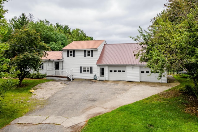 230 W Old Main Rd, Lowell, ME 04493 - view of front of property with driveway, a metal roof, an attached garage, and a front yard