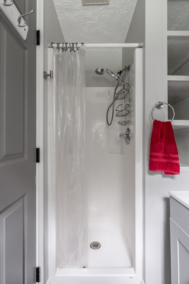 230 W Old Main Rd, Lowell, ME 04493 - bathroom with a shower with shower curtain, vanity, and a textured ceiling