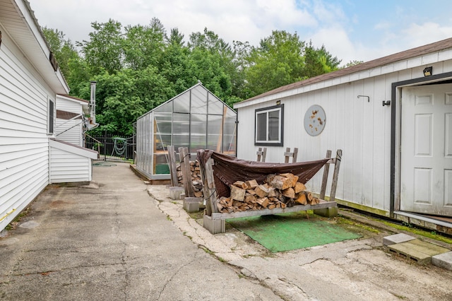 230 W Old Main Rd, Lowell, ME 04493 - view of patio with a greenhouse and an outbuilding