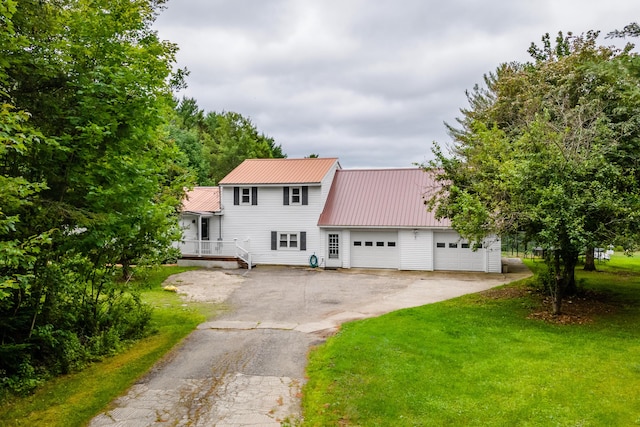 230 W Old Main Rd, Lowell, ME 04493 - view of front facade with an attached garage, driveway, a front yard, and a metal roof