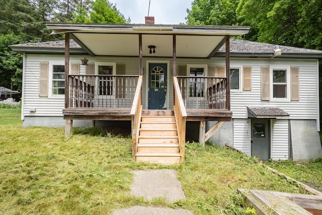 180 Lawrence St, Dover-Foxcroft, ME 04426 - view of front facade with covered porch, a chimney, and a front lawn