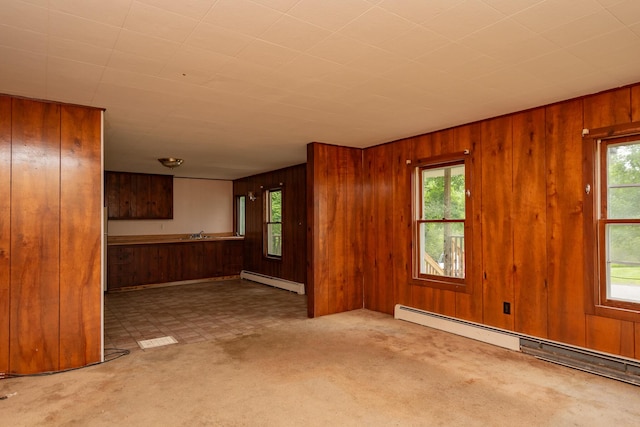 180 Lawrence St, Dover-Foxcroft, ME 04426 - unfurnished living room with a baseboard radiator, wood walls, healthy amount of natural light, and carpet floors