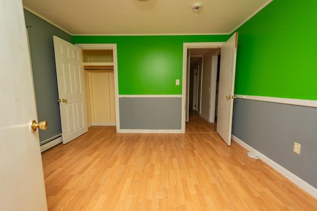 180 Lawrence St, Dover-Foxcroft, ME 04426 - unfurnished bedroom with a baseboard heating unit, wood finished floors, ornamental molding, and a closet