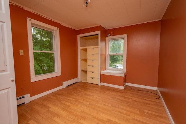 180 Lawrence St, Dover-Foxcroft, ME 04426 - empty room with a baseboard heating unit, light wood-style flooring, healthy amount of natural light, and ornamental molding