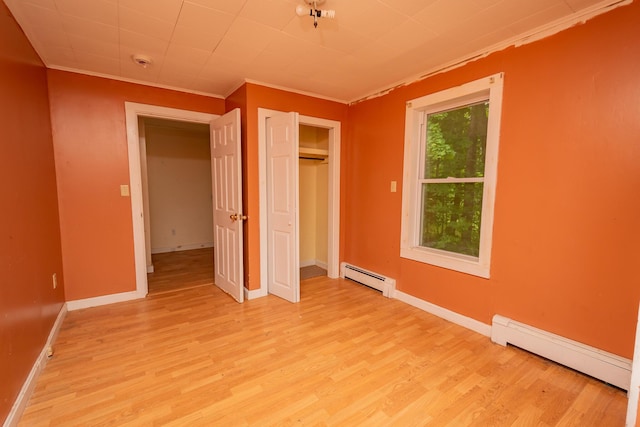180 Lawrence St, Dover-Foxcroft, ME 04426 - unfurnished bedroom featuring a baseboard heating unit, light wood finished floors, crown molding, and a closet