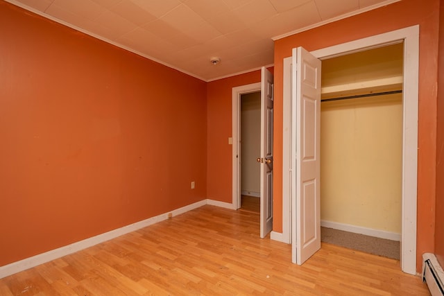 180 Lawrence St, Dover-Foxcroft, ME 04426 - unfurnished bedroom with light wood-type flooring, a baseboard radiator, crown molding, and a closet