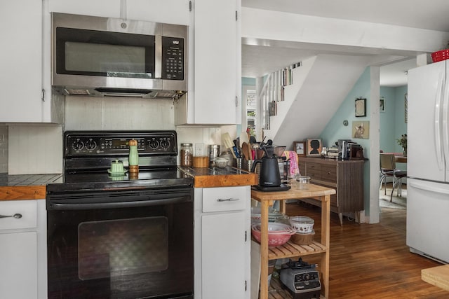26 Wesley St Ct, Bath, ME 04530 - kitchen featuring black / electric stove, stainless steel microwave, freestanding refrigerator, and white cabinetry