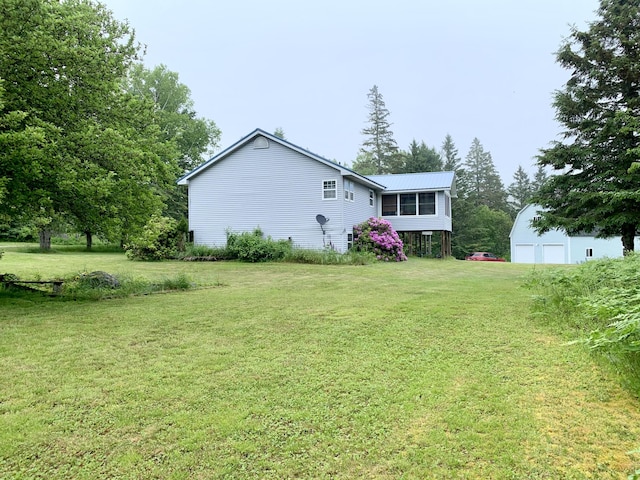 150 Leach Point Rd, Perry, ME 04667 - view of side of home featuring a yard, a metal roof, a detached garage, and an outbuilding
