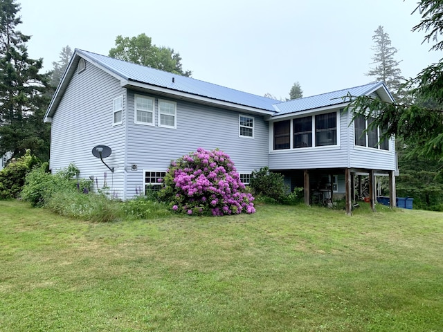 150 Leach Point Rd, Perry, ME 04667 - rear view of property with a sunroom, a lawn, and a metal roof