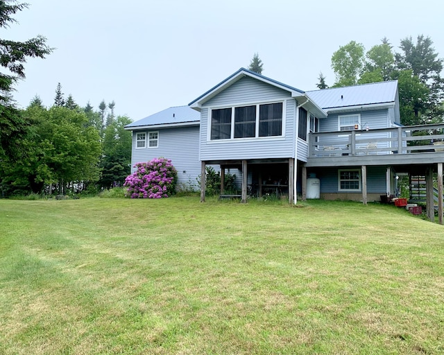 150 Leach Point Rd, Perry, ME 04667 - rear view of property with a metal roof, a wooden deck, and a lawn