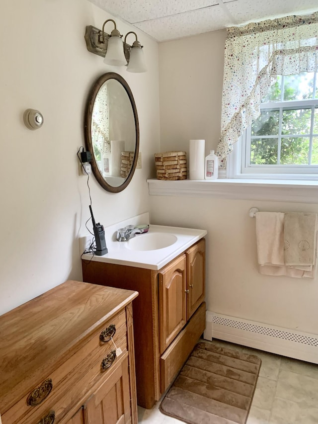 150 Leach Point Rd, Perry, ME 04667 - bathroom featuring baseboard heating, vanity, tile patterned floors, and a paneled ceiling