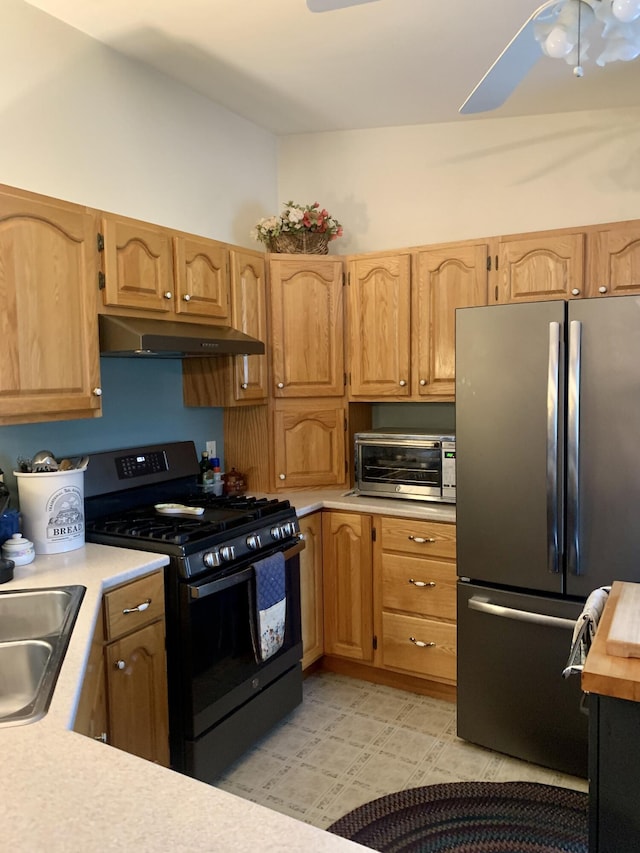 150 Leach Point Rd, Perry, ME 04667 - kitchen with black gas stove, freestanding refrigerator, under cabinet range hood, light countertops, and a ceiling fan