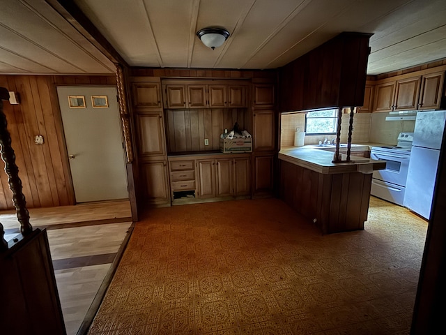 489 Lovejoy Pond Rd, Fayette, ME 04349 - kitchen with a peninsula, wooden walls, white electric stove, freestanding refrigerator, and brown cabinets